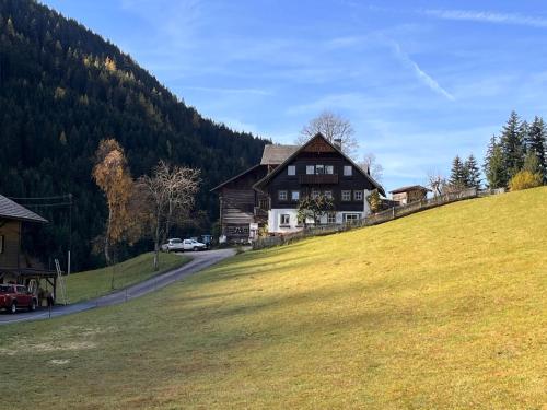 a large house on a hill with a grass field at Apartment Knaushof by Interhome in Ramsau am Dachstein
