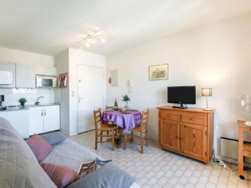 cocina y sala de estar con mesa y TV. en Apartment Régina-2 by Interhome, en Sainte-Maxime
