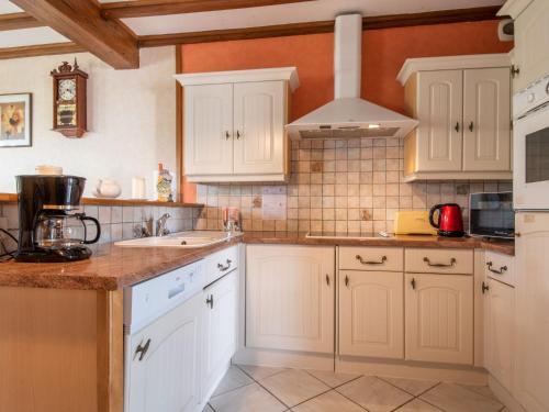 une cuisine avec des armoires blanches et un évier dans l'établissement Holiday Home Tytisa N-2 by Interhome, à Barneville-Carteret