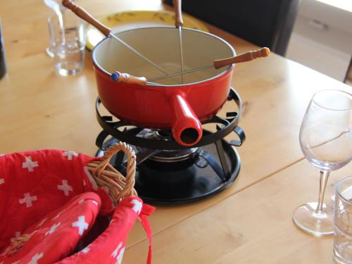 een pot op een fornuis met een wijnglas bij Apartment Les Girolles B15 by Interhome in Villars-sur-Ollon