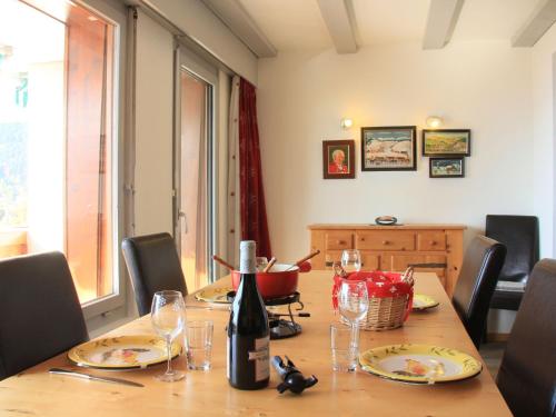 a dining room table with a bottle of wine and glasses at Apartment Les Girolles B15 by Interhome in Villars-sur-Ollon