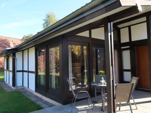 a glass extension of a house with a table and chairs at Holiday Home Robinson by Interhome in Machtlos