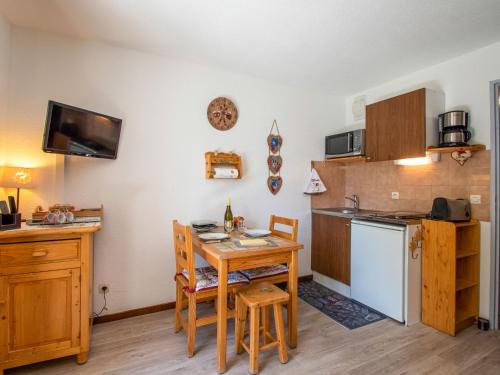 Il comprend une cuisine avec une table et une petite cuisine équipée d'un réfrigérateur. dans l'établissement Apartment Chalets du Soleil-21 by Interhome, à Les Deux Alpes