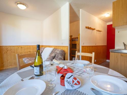 een tafel met borden en een fles wijn erop bij Apartment Sarvan 315 by Interhome in Les Menuires