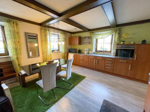 a kitchen with a table and chairs in a room at Apartment Kühbeck-2 by Interhome in Bischofsmais