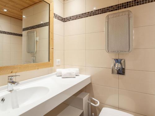 une salle de bain avec un lavabo et un miroir et des toilettes dans l'établissement Apartment Les Tommeuses - Val Claret-2 by Interhome, à Tignes
