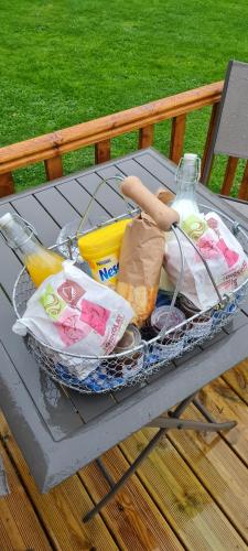 Saint-Martin-Saint-Firmin的住宿－Les Mini-Chaumières，坐在野餐桌上的一篮子食物