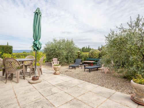 a patio with a table and chairs and an umbrella at Holiday Home Les Vignes by Interhome in Ménerbes