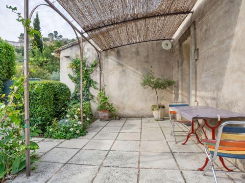 an outdoor patio with a table and chairs at Holiday Home Les Vignes by Interhome in Ménerbes