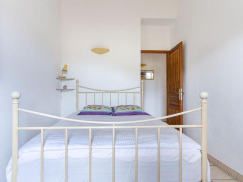 a white bed in a white room with a white bedspread at Holiday Home Les Vignes by Interhome in Ménerbes