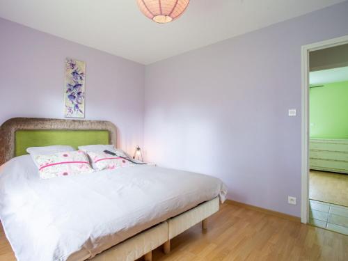 une chambre avec un lit blanc avec des oreillers roses dans l'établissement Holiday Home Clos d'Amont by Interhome, à Portbail