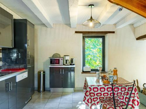 une cuisine avec une table aux motifs rouge et blanc dans l'établissement Holiday Home Les Trois Baudets by Interhome, à Elliant