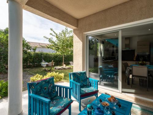 un patio avec deux chaises bleues et une table dans l'établissement Holiday Home Villa Marie-Jo by Interhome, à Cervione