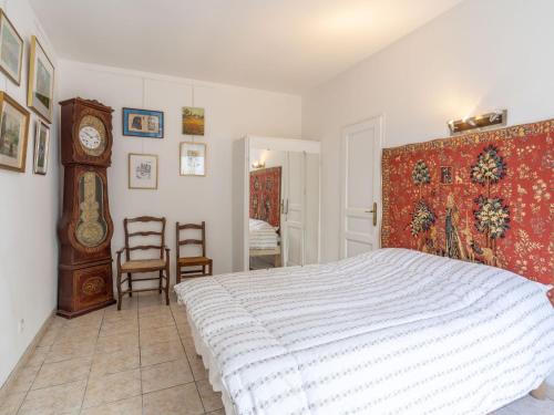 1 dormitorio con 1 cama y reloj de abuelo en Apartment Le Chalet by Interhome, en Cabourg