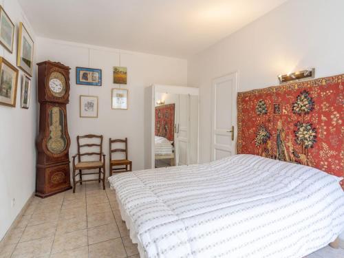 a bedroom with a bed and a grandfather clock at Apartment Le Chalet by Interhome in Cabourg