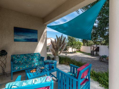 d'une terrasse avec 2 chaises bleues et un canapé. dans l'établissement Holiday Home Villa Marie-Jo by Interhome, à Cervione