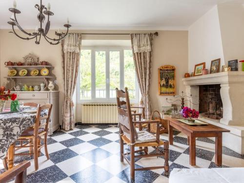 a living room with a table and chairs and a fireplace at Holiday Home Le Cèdre - MBE101 by Interhome in Ménerbes