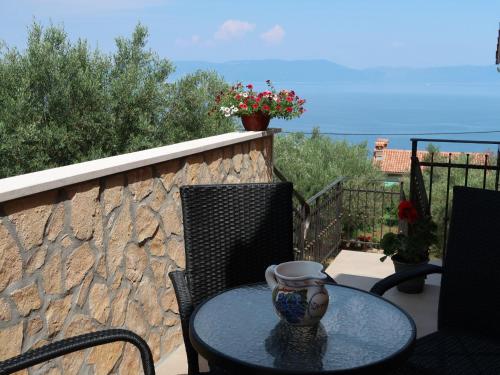 a table with a vase sitting on top of a balcony at Apartment Elsa-2 by Interhome in Ravni