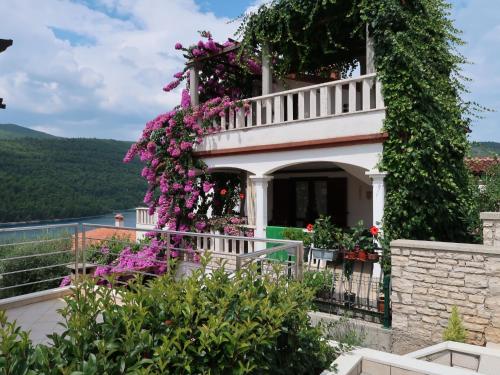 a house covered in flowers on a balcony at Apartment Violetta - LBN201 by Interhome in Labin