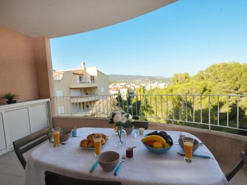 a table with fruit on a balcony with a view at Apartment Porto di Mar-5 by Interhome in Cavalaire-sur-Mer
