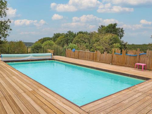 a swimming pool with a wooden deck and a swimming poolvisor at Holiday Home La Raze by Interhome in Bonneville-et-Saint-Avit-de-Fumadières