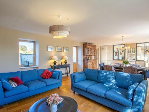 un salon avec deux canapés bleus et une cuisine dans l'établissement Holiday Home Balade Océane by Interhome, à Trégunc