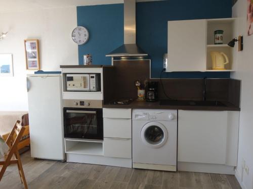 une cuisine avec un lave-linge et un micro-ondes dans l'établissement Apartment Marina 2-2 by Interhome, à Saint Cyprien Plage