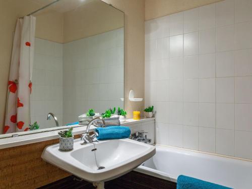 une salle de bain avec un lavabo, une baignoire et un miroir dans l'établissement Studio Vostok Zodiaque-15 by Interhome, au Corbier