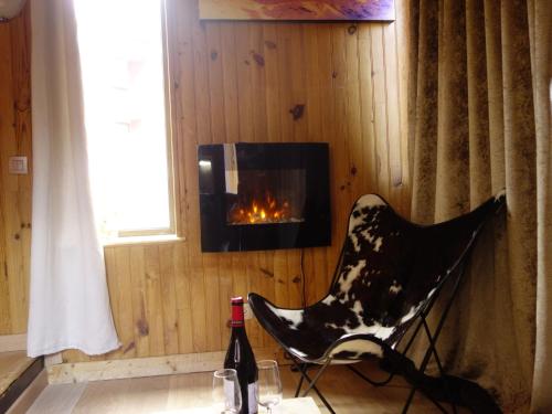- un fauteuil noir et blanc dans une chambre avec cheminée dans l'établissement Apartment Sérac A10 by Interhome, à Val Thorens