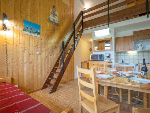 レ・メニュアールにあるApartment Les Asters-32 by Interhomeの木製の壁とらせん階段のあるキッチン
