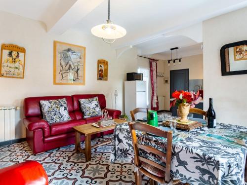 a living room with a red couch and a table at Holiday Home L'Olivier - MBE102 by Interhome in Ménerbes