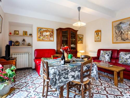 a living room with a table and a red couch at Holiday Home L'Olivier by Interhome in Ménerbes