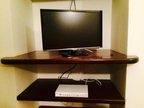 ein Computermonitor auf einem Holzregal in der Unterkunft TL Palazzo Fantuzzi in Bologna