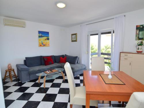 ein Wohnzimmer mit einem blauen Sofa und einem Tisch in der Unterkunft Apartment Nina by Interhome in Mimice