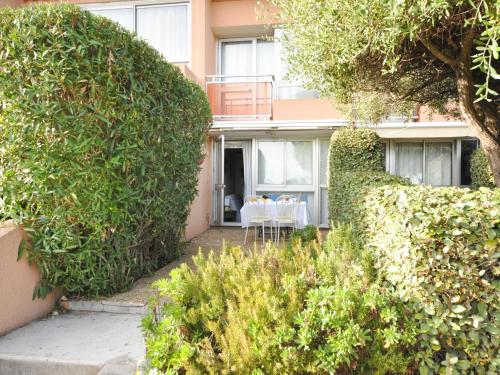 une maison avec de grandes haies devant elle dans l'établissement Apartment Les Jardins de la Mer-2 by Interhome, à Cavalaire-sur-Mer