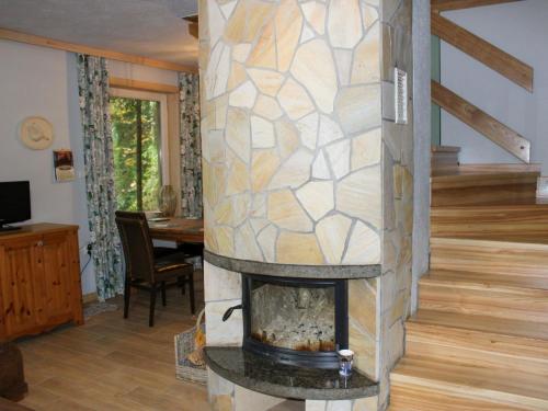 a fireplace in a living room with a stone wall at Holiday Home Gwiezdna by Interhome in Walne