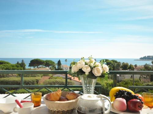 - une table de petit-déjeuner avec un vase de fleurs et de fruits dans l'établissement Apartment Riva Bella-2 by Interhome, à Cavalaire-sur-Mer
