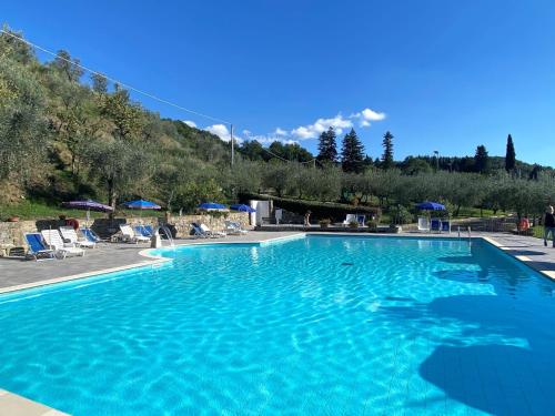 a large blue swimming pool with a mountain in the background at Apartment Villa Grassina-2 by Interhome in Pelago