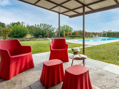 CortazzoneにあるHoliday Home Casa San Secondo by Interhomeのパティオ(赤い椅子、プール付)