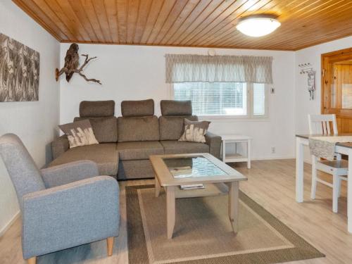 een woonkamer met een bank en een tafel bij Holiday Home Järvelä by Interhome in Kemijärvi