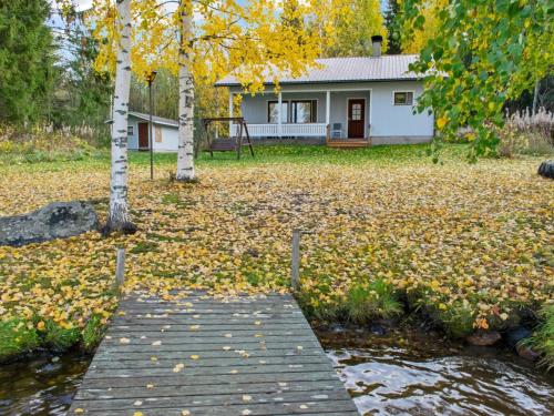 a house with a bridge in front of a yard with leaves at Holiday Home Iltarauha by Interhome in Ruvaslahti