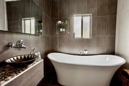 a bathroom with a large white tub and a sink at Sunset Haven in Shoalhaven Heads