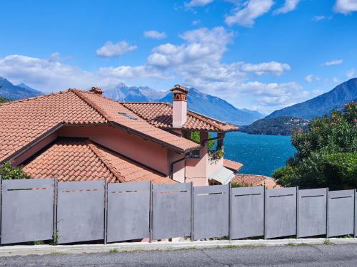 a house with a fence in front of a lake at Apartment Terrazzo fiorito by Interhome in Musso