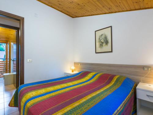 リニャーノ・サッビアドーロにあるHoliday Home Ranch Club by Interhomeのカラフルなベッドが備わるベッドルーム1室が備わります。