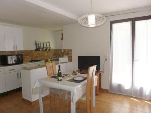 a kitchen with a table with a bottle of wine on it at Apartment Il était une fois-1 by Interhome in Saint-Aygulf