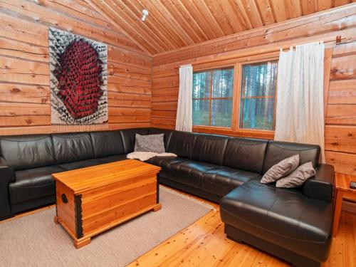 ein Wohnzimmer mit einem Ledersofa und einem Couchtisch in der Unterkunft Holiday Home Siula by Interhome in Nissi