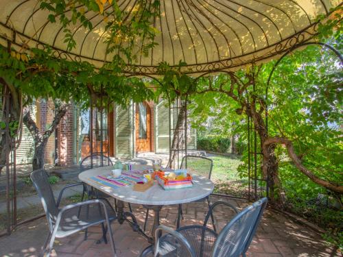 patio con tavolo e sedie sotto un pergolato di Holiday Home Borgo della Limonaia-3 by Interhome a Pieve a Nievole