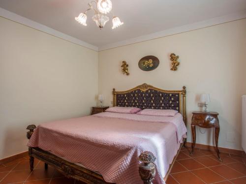 a bedroom with a bed with pink sheets and a chandelier at Holiday Home Borgo della Limonaia-3 by Interhome in Pieve a Nievole