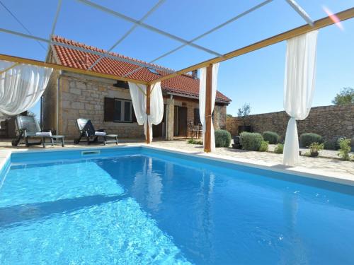 ein Pool mit einer Pergola und ein Haus in der Unterkunft Holiday Home Marija by Interhome in Bogatić