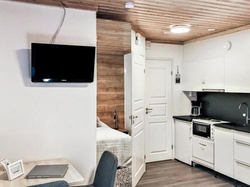 uma pequena cozinha com uma cama e uma televisão na parede em Holiday Home Weekend duo by Interhome em Lahdenperä